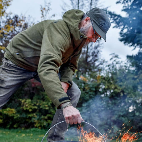 Mann in grüner Deubelskerl-Lodenjacke im Garten