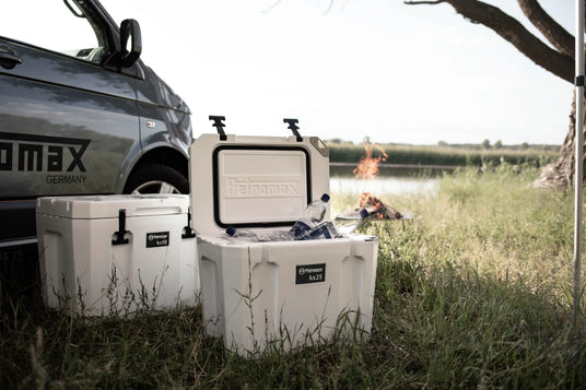 Zwei Petromax-Kulboxen auf dem Rasen neben einem Auto