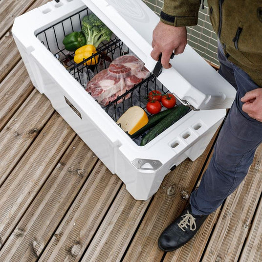 Person öffnet eine Petromax Kühlbox voller Essen