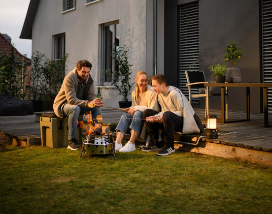 Personen braten Essen auf einem Atago-Grill auf der Terrasse