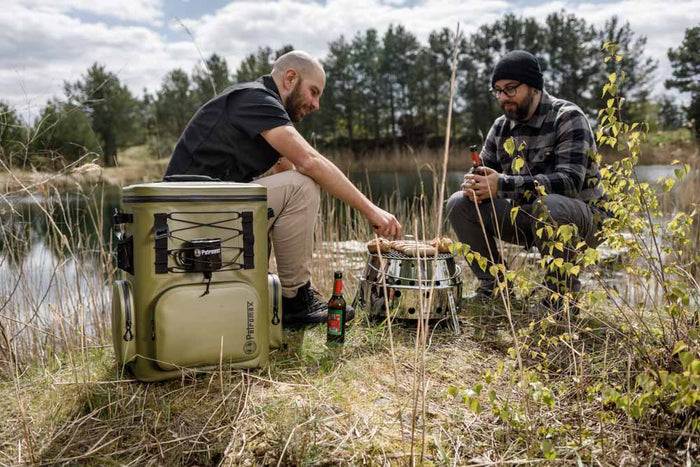 Zwei Personen grillen auf einem Atago-Grill am See