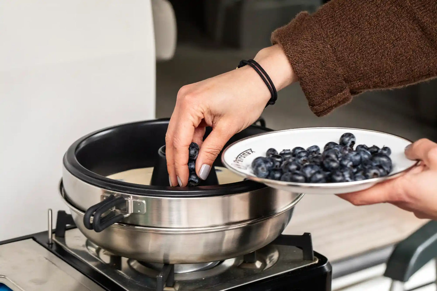 Eine Person bereitet Teig im Dimego Camping Backofen vor