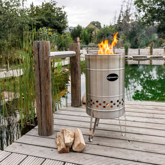 Brennende Feuertonne Pyron auf einer Terrasse mit Blick auf das Wasser