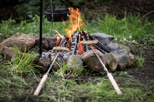 Würstchen auf einem Lagerfeuer-Spieß von Petromax über dem offenen Feuer gegrillt